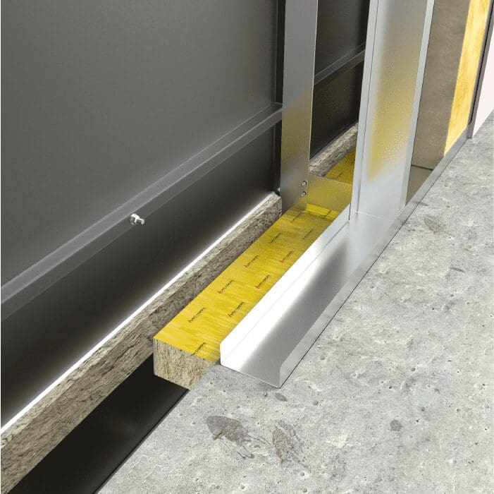 Close-up of a building wall section showing insulation, metal framing, and a concrete floor.