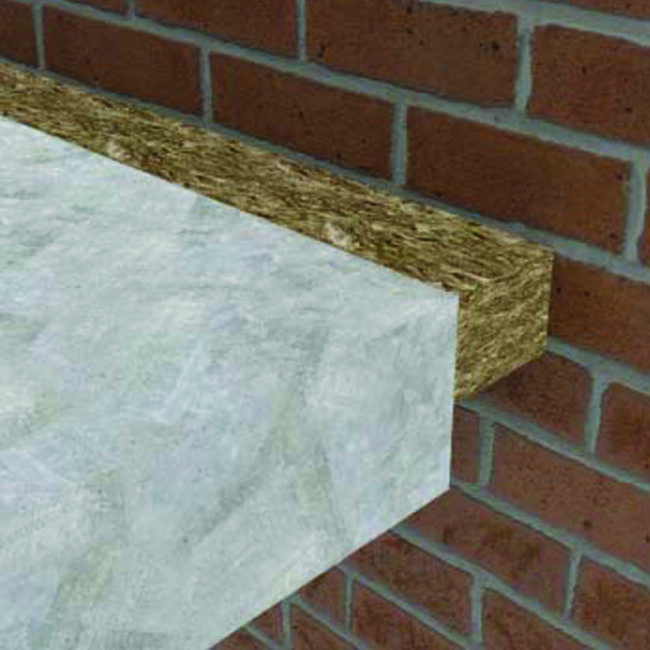 Close-up of a concrete slab insulated with a layer of rigid insulation board next to a brick wall.