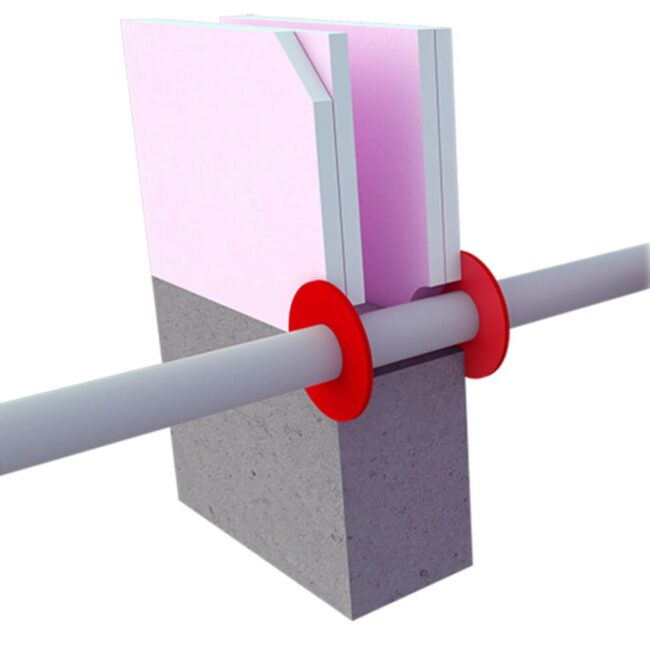 A pipe passes through an insulated wall with red seals on both sides of the opening.